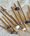 Various styles of replica drop spindles from different periods with whorls made from soapstone, antler and lead alloy. Size: average 200mm long